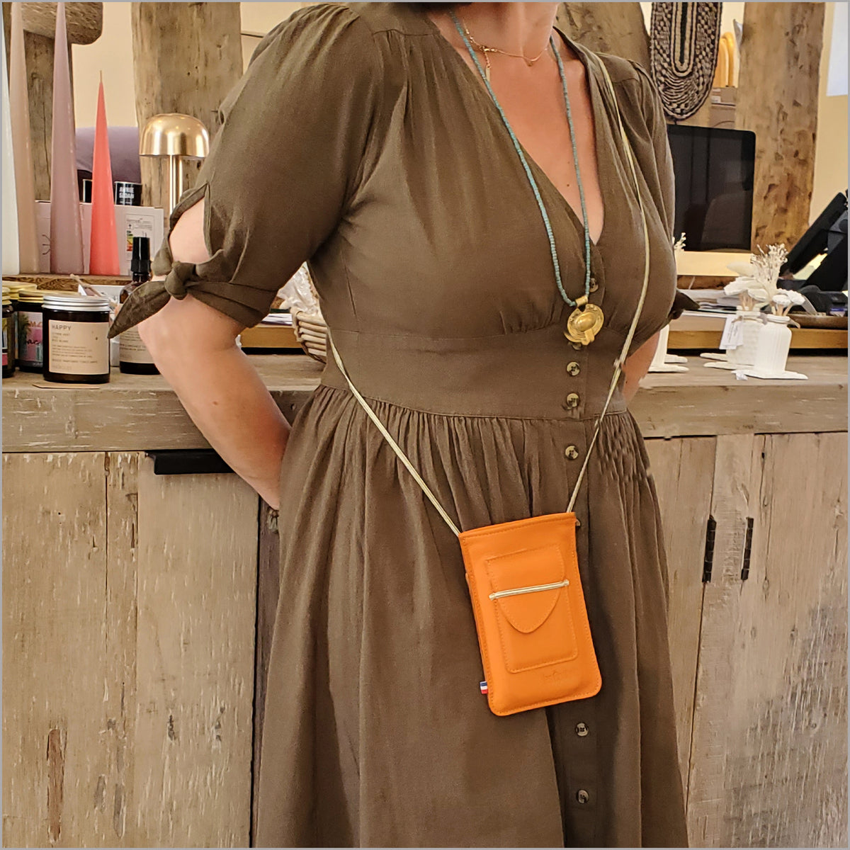 Orange leather phone pouch with adjustable shoulder strap